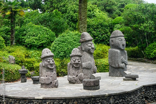 Obraz Several stone grandfather statues on Jeju Island in South Korea with forest in background