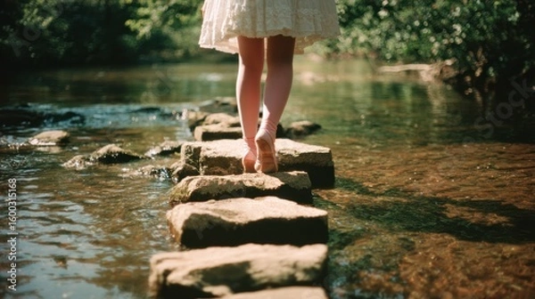 Fototapeta Serene Journey Across the Water: A person with bare feet delicately walks across a series of stepping stones, framed by lush greenery and water, evoking a sense of peace, harmony, and exploration.