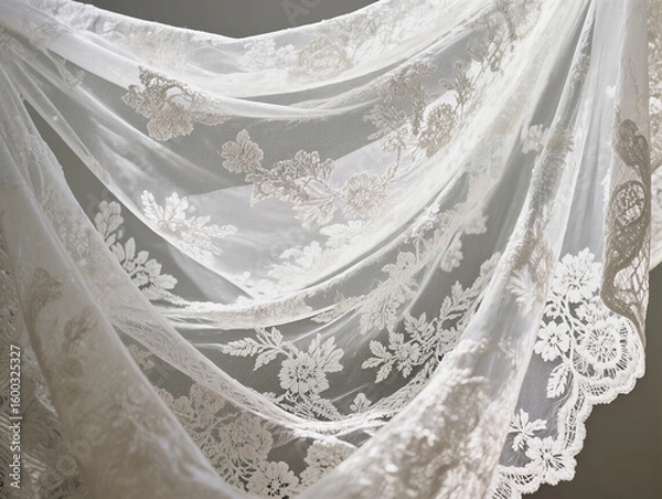 Fototapeta Delicate white lace fabric with a close-up floral pattern. The folds in the lace fabric create elegant texture and depth for wedding and fashion designs.