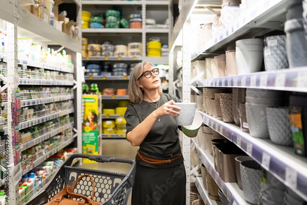 Obraz Woman selecting items in a home goods store while engaging with her shopping experience