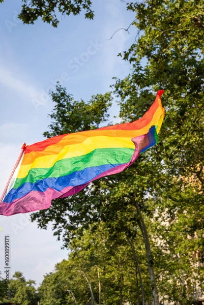 Obraz A colorful rainbow flag waves in the summer air during pride celebrations in Barcelona. The lively atmosphere reflects joy, acceptance, and unity among the LGBTQ+ community.