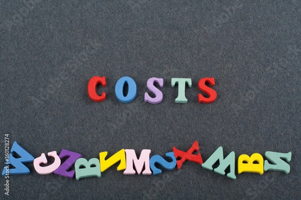 Fototapeta costs word on black board background composed from colorful abc alphabet block wooden letters, copy space for ad text. Learning english concept.