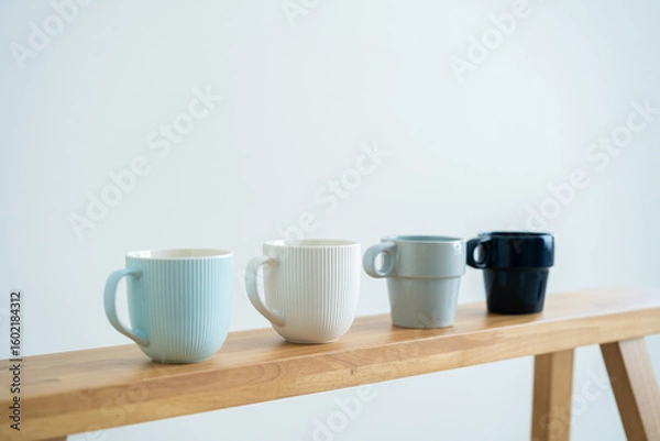 Fototapeta Minimalist cups on a wooden bench against white wall