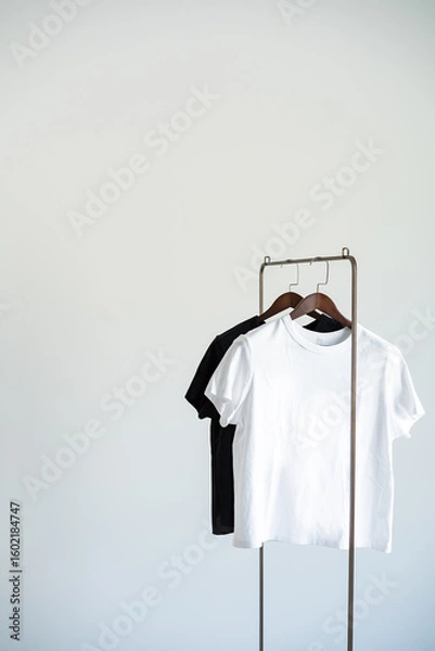 Fototapeta Minimal clothing setup with black and white T-shirts on hangers