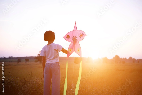 Obraz Child flying a multicolored kite outside