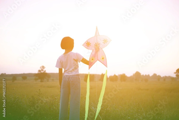 Obraz Child flying a multicolored kite outside