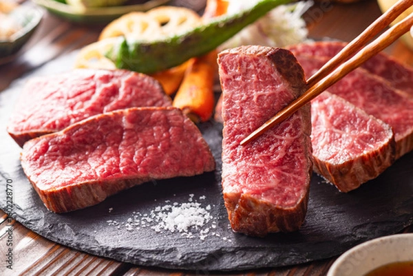 Fototapeta 【黒毛和牛ステーキ】レアで美しく焼き上げた黒毛和牛モモ肉のステーキ。ジューシーな肉の旨みを引き立てるのは、素揚げした季節の野菜と彩り豊かな薬味。わさびや塩、日本酒とともに、和の美味を贅沢に味わう一皿です。