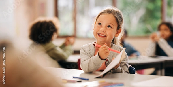 Obraz Young girl drawing in classroom during back to school season