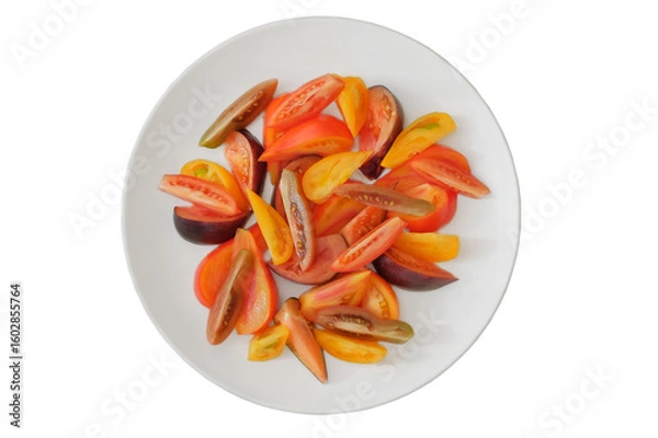 Fototapeta Sliced tomato in white plate. Tomatoes in a clay plate isolate on white background. Orange and red ripe vegetables. Top view.