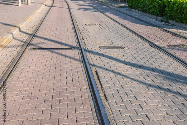 Fototapeta Tram tracks with tiles laid between the rails. Urban transport and roads for trams. View of the road and rails. Tram tracks.