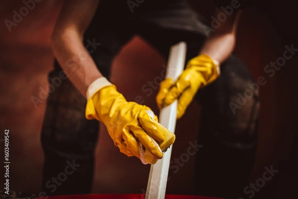Fototapeta A worker washes a plastic part of a frame with a sponge.