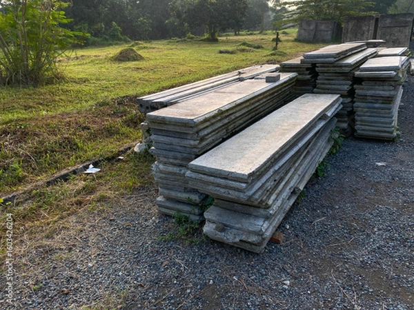 Fototapeta Pile of left over thin long concrete masonry block slabs, on the road side