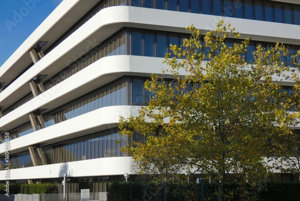 Fototapeta A new corporate building with a modern design, many windows, and a white facade near Geneva, Switzerland