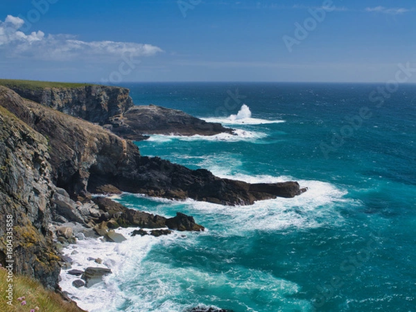 Fototapeta Rugged cliffs meet the vibrant blue Atlantic Ocean at Mizen Head, Ireland, under a clear sky.