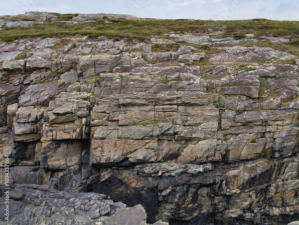 Fototapeta Detailed view of layered rock formations with fractures at Sheeps Head, Ireland, capturing natures artistry.