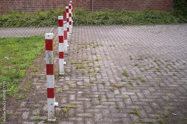 Obraz Red and white traffic bollards defining parking space limits