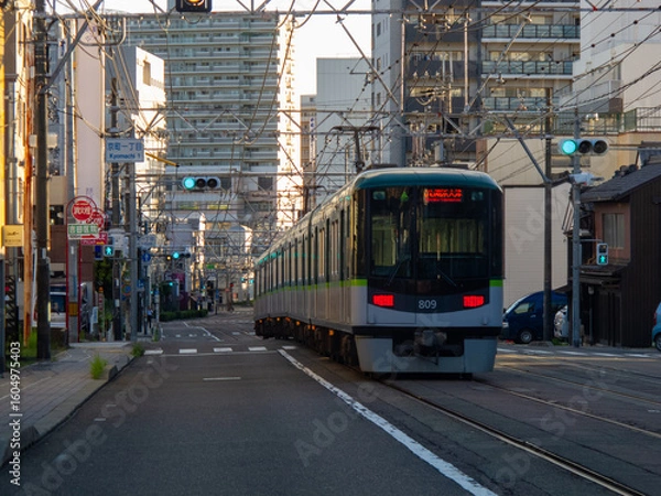Fototapeta 横を走る車から見える路面電車が走る道路と街並みの風景