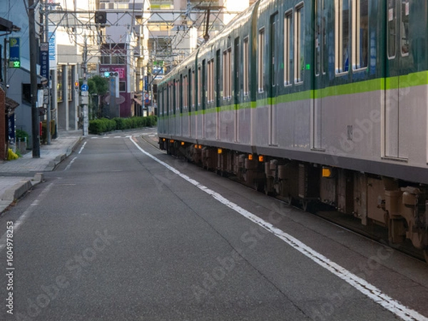 Fototapeta 横を走る車から見える路面電車が走る道路と街並みの風景