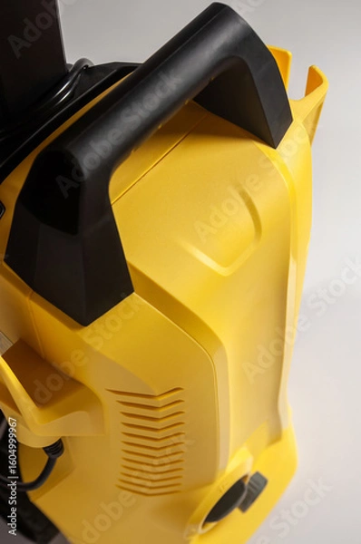 Fototapeta Close-up of a yellow and black pressure washer, highlighting its design and functionality.