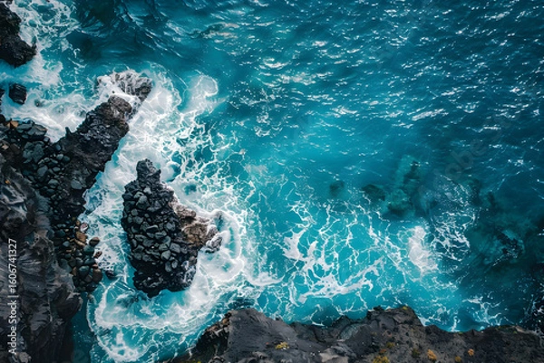 Fototapeta Birds eye view of sharp black volcanic rocks meet