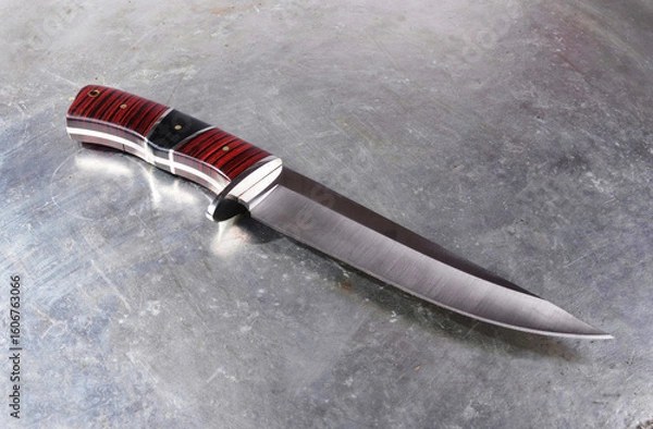 Fototapeta Hunting knife , with a wide single-edged sharpened blade, on an isolated background.