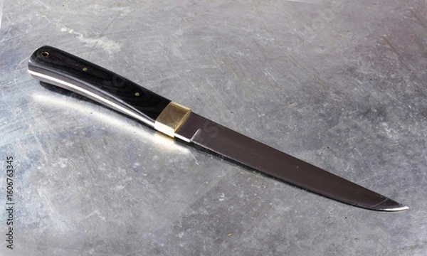 Fototapeta Hunting knife, with a wide single-sided sharpened blade, on an isolated background.