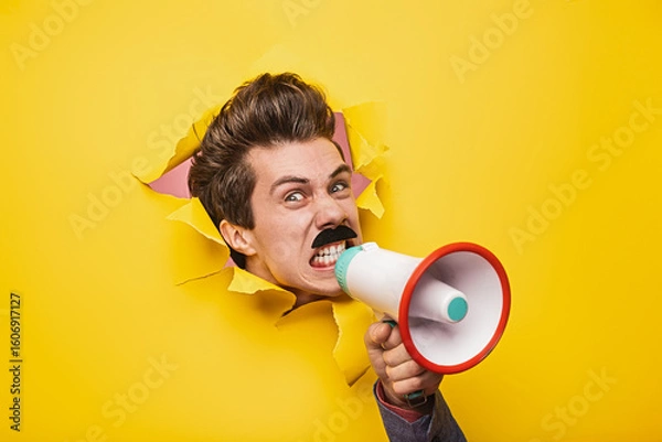 Obraz Person yelling into a megaphone while emerging through a yellow paper wall, symbolizing communication, attention-grabbing, and expression of boldness and creativity. Vibrant and attention-focused