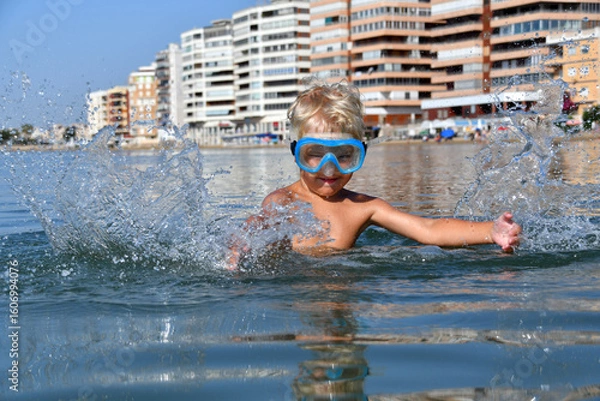 Fototapeta Little Boy Playing and Splashing in the Sea with a Snorkel Mask