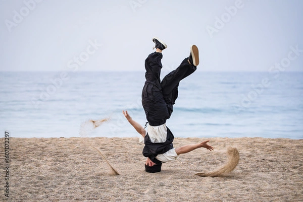 Obraz 夕暮れの砂浜で迫力のあるヘッドスピンを決めるブレイクダンサー