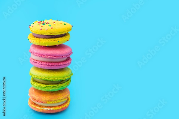 Obraz A few brightly colored stacked macarons on blue background. Mixed of colorful macaroni or pasta cake. Tasty and colorful french macarons. Culinary, cooking concept, styling food. Add your text.
