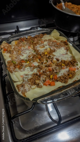 Obraz Vertical photo of a delicious and juicy lasagna, ground beef with pasta and red sauce, homemade.