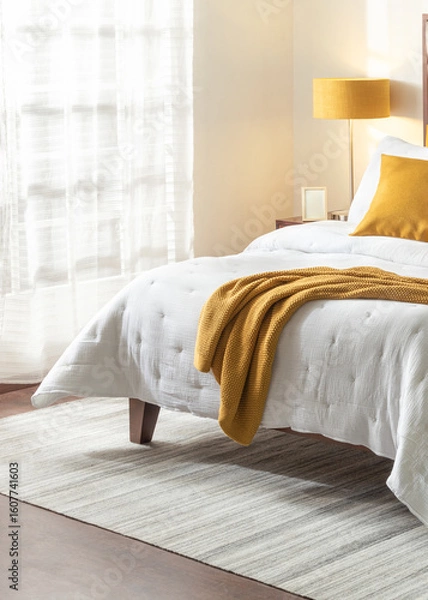Fototapeta Modern Mid-Century bedroom design, a serene summer ambiance, cozy white bed, vibrant throw blanket, framed on a warm, naturally lit setting with sheer curtains, perfect relaxed and homey atmosphere.