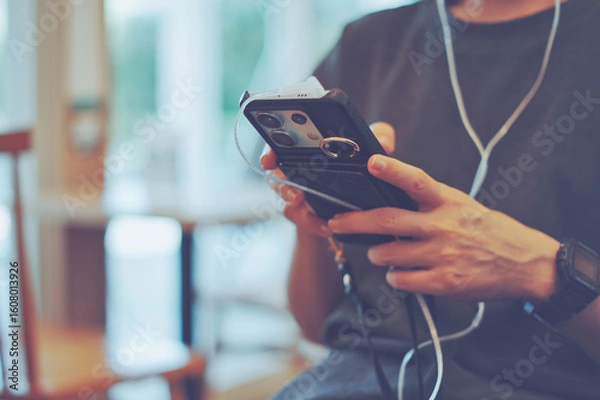 Fototapeta スマホで音楽を聞く女性