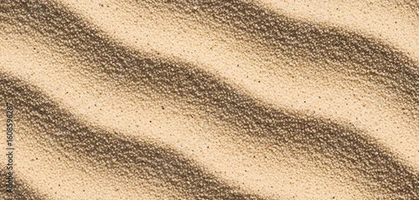 Fototapeta Sand dunes with rippled texture in warm light, highlighting natural formations and soft golden tones that evoke desert warmth and organic surface movement in outdoor visual themes.