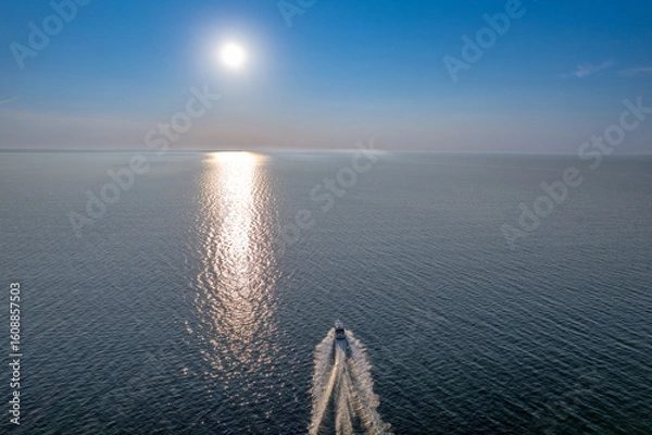 Fototapeta Drone view of a luxury motor yacht sailing on calm sea water on a sunny summer day.