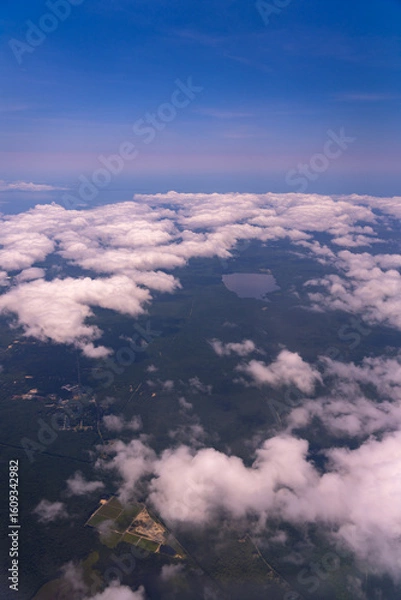 Fototapeta Aerial view of clouds, forest, and lake.
