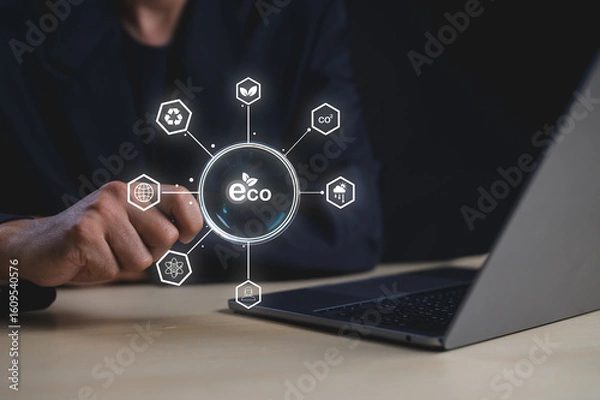 Fototapeta A person interacts with a digital eco-friendly concept hologram featuring sustainability and environmental icons above a laptop.