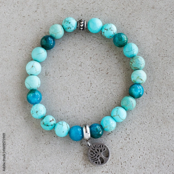 Obraz Turquoise and teal stone bracelet with tree of life charm. Blue and turquoise bracelet with silver bead and charm. Natural stone bracelet with symbolic pendant