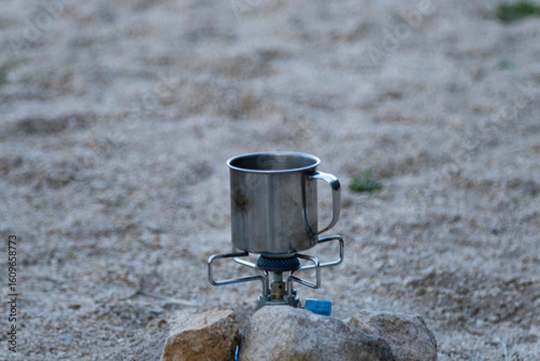 Fototapeta a mug on the camping gas burner hided in stones