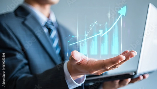 Fototapeta Businessman holding laptop with upward trending graph overlayed on hand showing growth concept