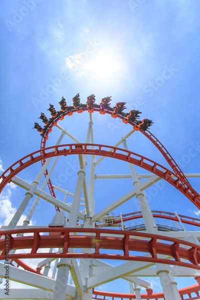 Fototapeta Red roller coaster rail with blue sky in background