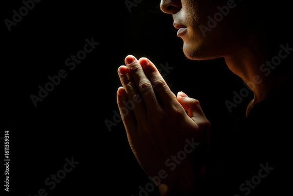 Fototapeta Person praying in darkness with hope.
