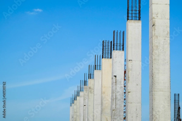 Fototapeta Reinforced concrete column structure in construction site with blue sky background