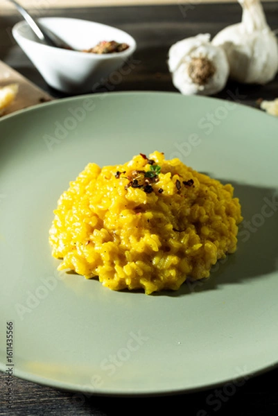 Obraz Saffron risotto in a rustic composition with garlic and parmesan cheeseù