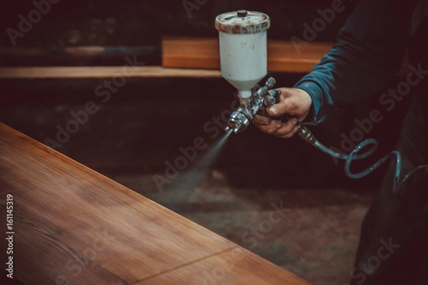 Obraz Master painter in a factory - industrial painting  wood with spray gun. Soft focus. Shallow DOF.