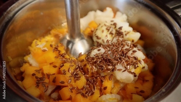 Fototapeta Chopped vegetables with flax seeds in a pot, ready to be blended with a hand blender. A healthy and colorful base for a homemade vegetarian puree or soup.