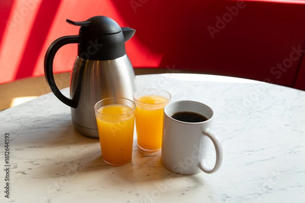 Fototapeta Coffee, Orange Juice and Thermos on Marble Table in Café Setting