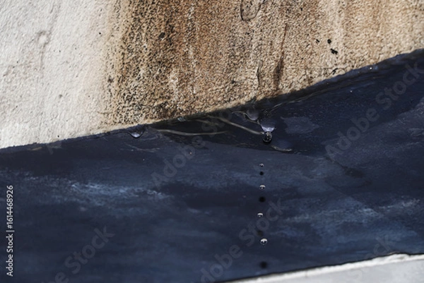 Fototapeta A few drops of water from the wet wall, the path of the water flow leaves a brownish trail on the white wall at the top