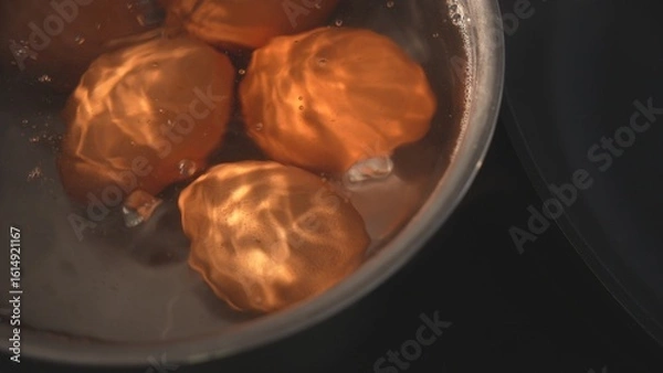 Fototapeta Top view of brown eggs boiling in kitchen pot
