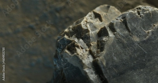 Fototapeta Close-up of layered slate rock with cracked lines and subtle blue shadows